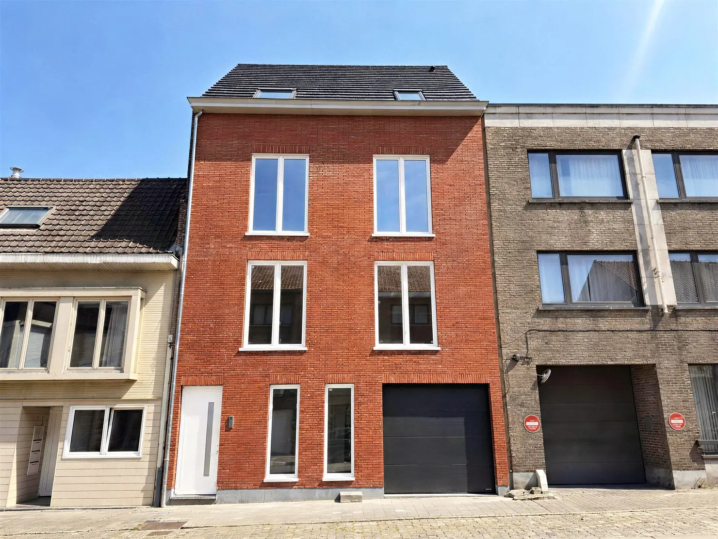 Straatgevel van Bazelhof in rode baksteen met zwart schrijnwerk